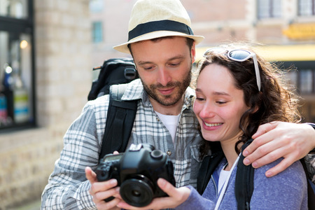 View of Young couple of tourist watching photographs on cameraの写真素材