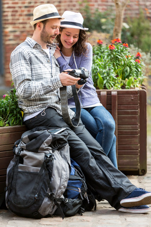 View of a Young couple of tourist watching photographs during a breakの写真素材