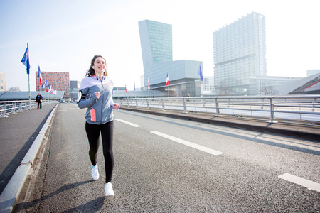 View of a Young attractive woman running downtownの写真素材