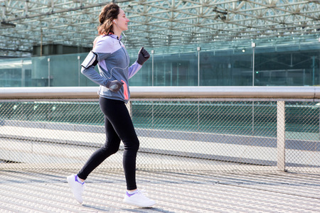 View of a Young attractive woman running downtownの写真素材