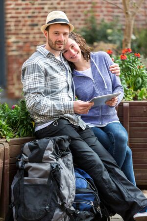 View of a Couple of attractive tourists using tablet during a pauseの写真素材