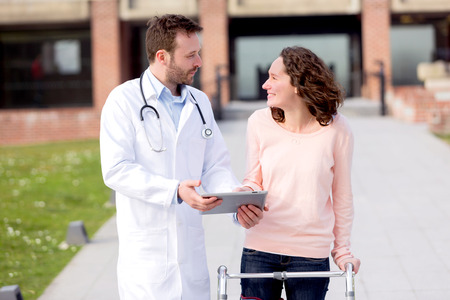 View of a Doctor showing reeducation's tips on tabletの写真素材
