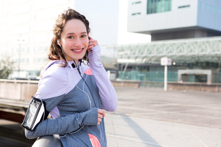 View of a Young attractive woman adjust her music player before runningの写真素材