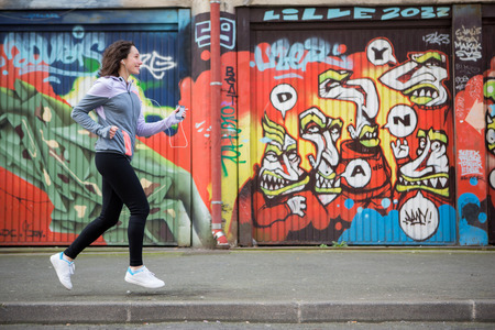 View of a Young attractive woman running downtownの写真素材