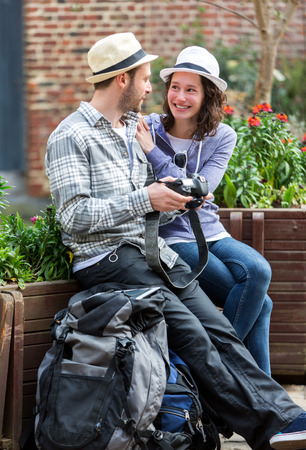 View of a Young couple of tourist watching photographs during a breakの写真素材