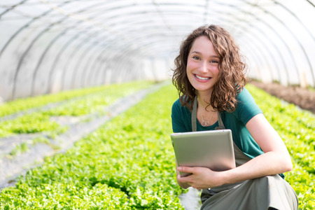 View of an attractive farmer in a greenhouse using tabletの写真素材
