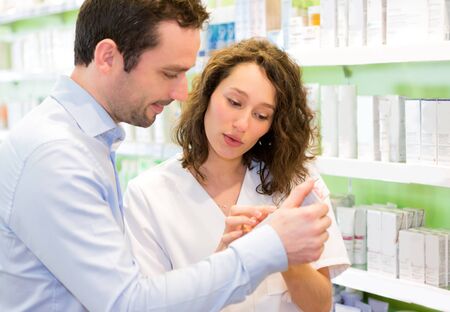 VIew of an Attractive pharmacist advising a customerの写真素材