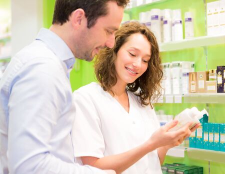 VIew of an Attractive pharmacist advising a patientの写真素材