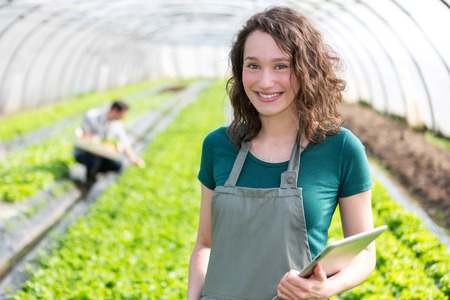 View of an attractive farmer in a greenhouse using tabletの写真素材