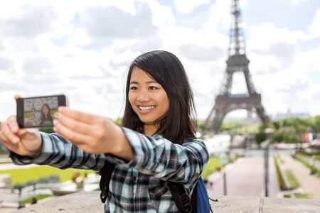 View of a Young attractive asian tourist in Paris taking selfieの写真素材