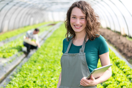 View of an attractive farmer in a greenhouse using tabletの写真素材