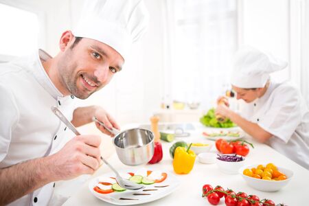 View of a Young attractive professional chef cooking in his kitchenの写真素材