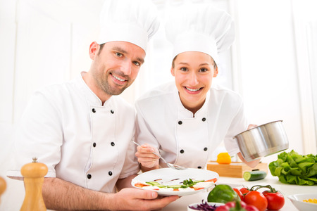 View of Young attractives professionals chefs cooking togetherの写真素材