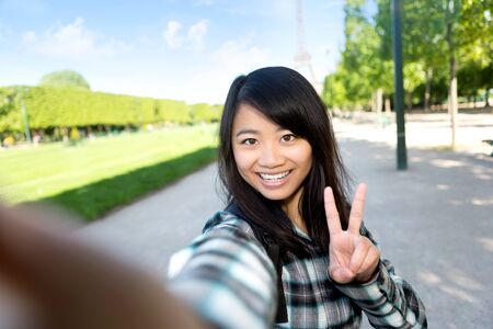 View of a Young attractive asian tourist in Paris taking selfieの写真素材