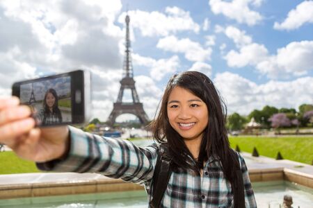 View of a Young attractive asian tourist in Paris taking selfieの写真素材