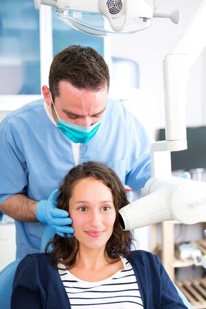 View of a Young attractive dentist doing a radiography of woman teethの写真素材