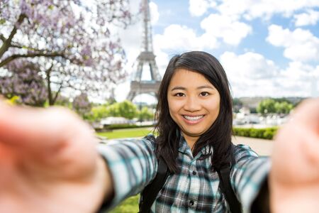 View of a Young attractive asian tourist in Paris taking selfie