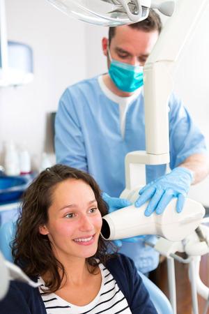 View of a Young attractive dentist doing a radiography of woman teethの写真素材
