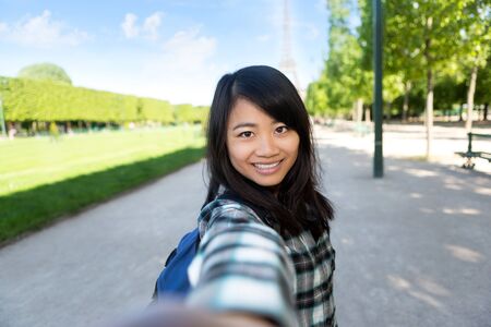 View of a Young attractive asian tourist in Paris taking selfie