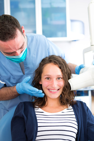 View of a Young attractive dentist doing a radiography of woman teethの写真素材