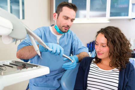 View of a Young attractive dentist explaning his work to a patientの写真素材