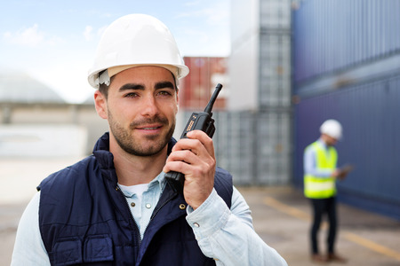 View of a Young Attractive docker using talkie walkie at workの写真素材