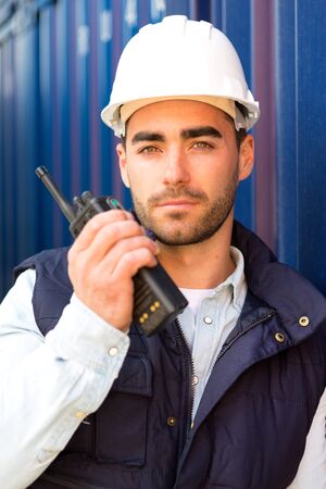View of a Young Attractive docker using talkie walkie at workの写真素材