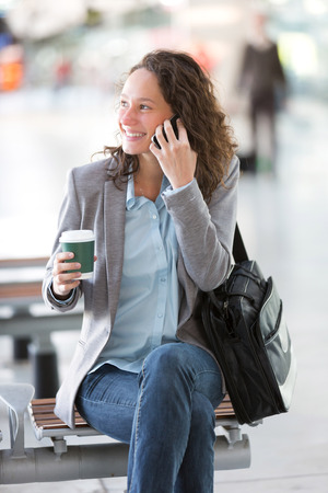 View of a Young attractive business woman using smartphone drinking coffeeの写真素材