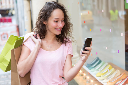 View of a Young attractive woman using mobile during shoppingの写真素材