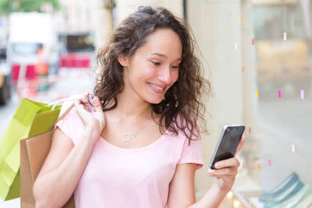 View of a Young attractive woman using mobile during shoppingの写真素材