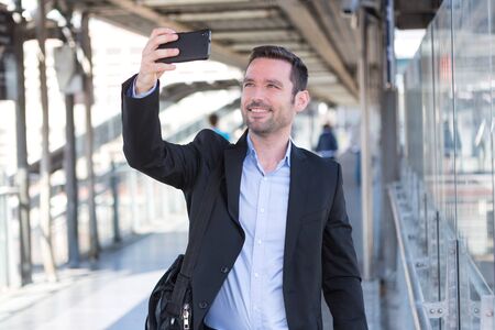 View of a Young attractive businessman taking some selfiesの写真素材