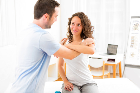 View of an Young attractive woman being manipulated by physiotherapistの写真素材