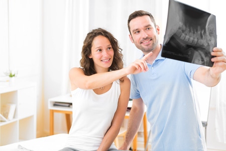 View of a Young attractive physiotherapist analysing X-ray with patientの写真素材
