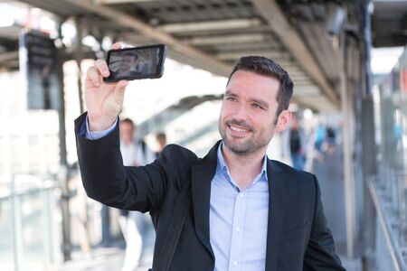 View of a Young attractive businessman taking some selfiesの写真素材