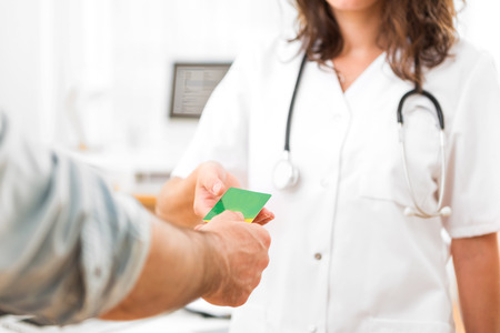 View of a Young attractive doctor taking health insurance cardの写真素材