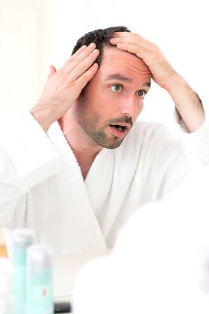 View of aYoung attractive man taking care of his hairの写真素材