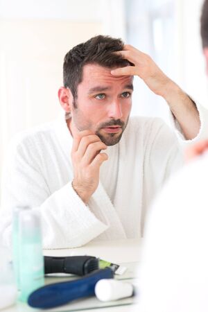 View of aYoung attractive man taking care of his hairの写真素材