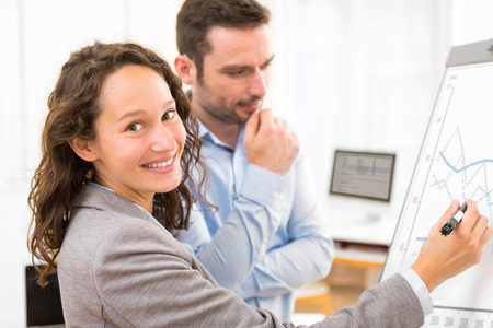 View of  Business man and woman analysing stats on a paperboardの写真素材