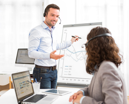 View of a Business man and woman analysing stats while doing video conferenceの写真素材