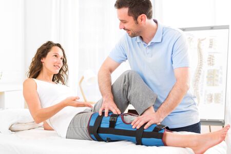 View of a Young attractive woman being manipulated by physiotherapistの写真素材