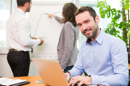 View of a Young attractive businessman working at the office with associatesの写真素材