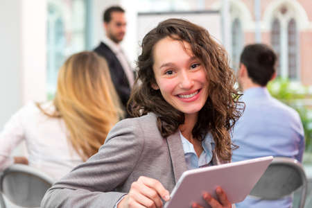 VIew of a Young attractive businesswoman working at the office with associatesの写真素材