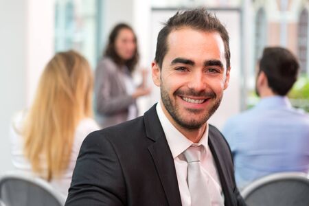 View of a Young attractive businessman working at the office with associatesの写真素材