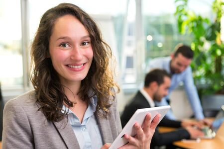 View of a Young attractive businesswoman working at the office with associatesの写真素材