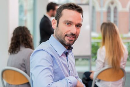 View of a Young attractive businessman working at the office with associatesの写真素材