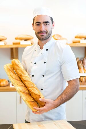 VIew of a Young attarctive baker working at the bakeryの写真素材