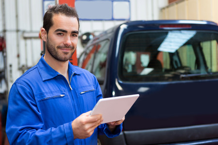 View of a Young attractive mechanic working at the garageの写真素材