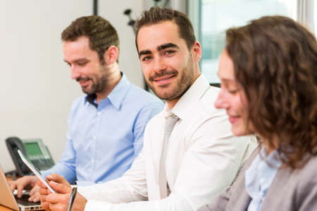 View of a Young attractive businessman working at the office with associatesの写真素材
