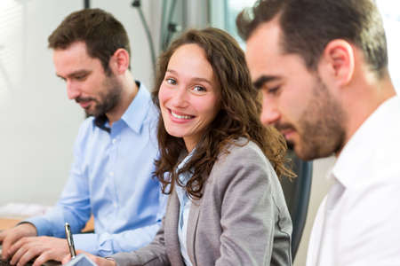 View of a Young attractive businesswoman working at the office with associatesの写真素材