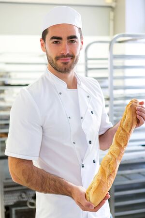 VIew of a Young attarctive baker working at the bakeryの写真素材